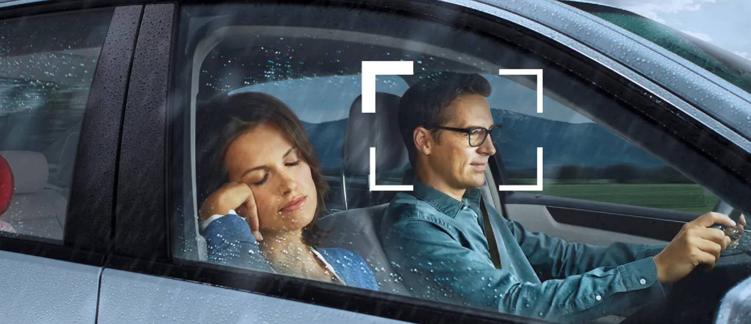 Familie im Auto, wo Tochter und Frau schlafen und Mann sitzt fokussiert am Lenker