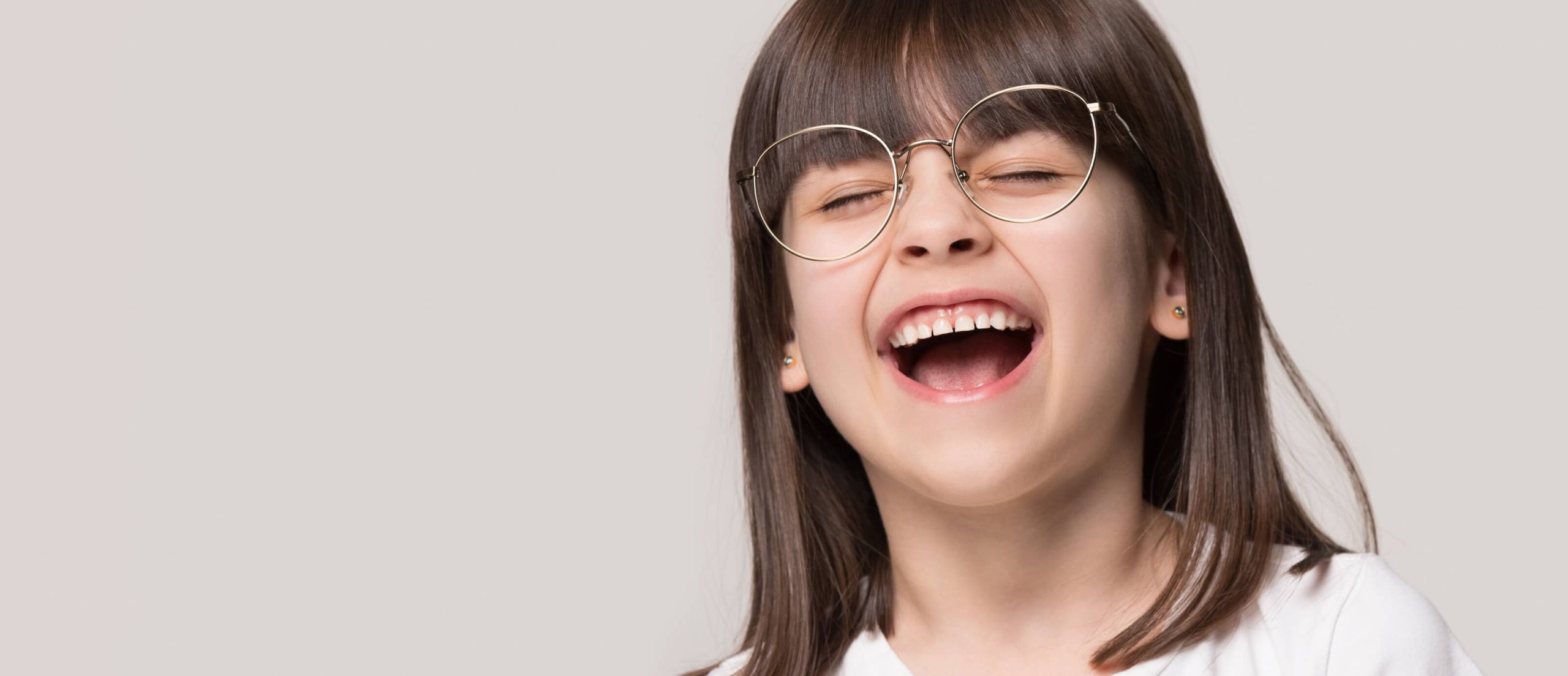 Mädchen mit Brille lacht sehr stark