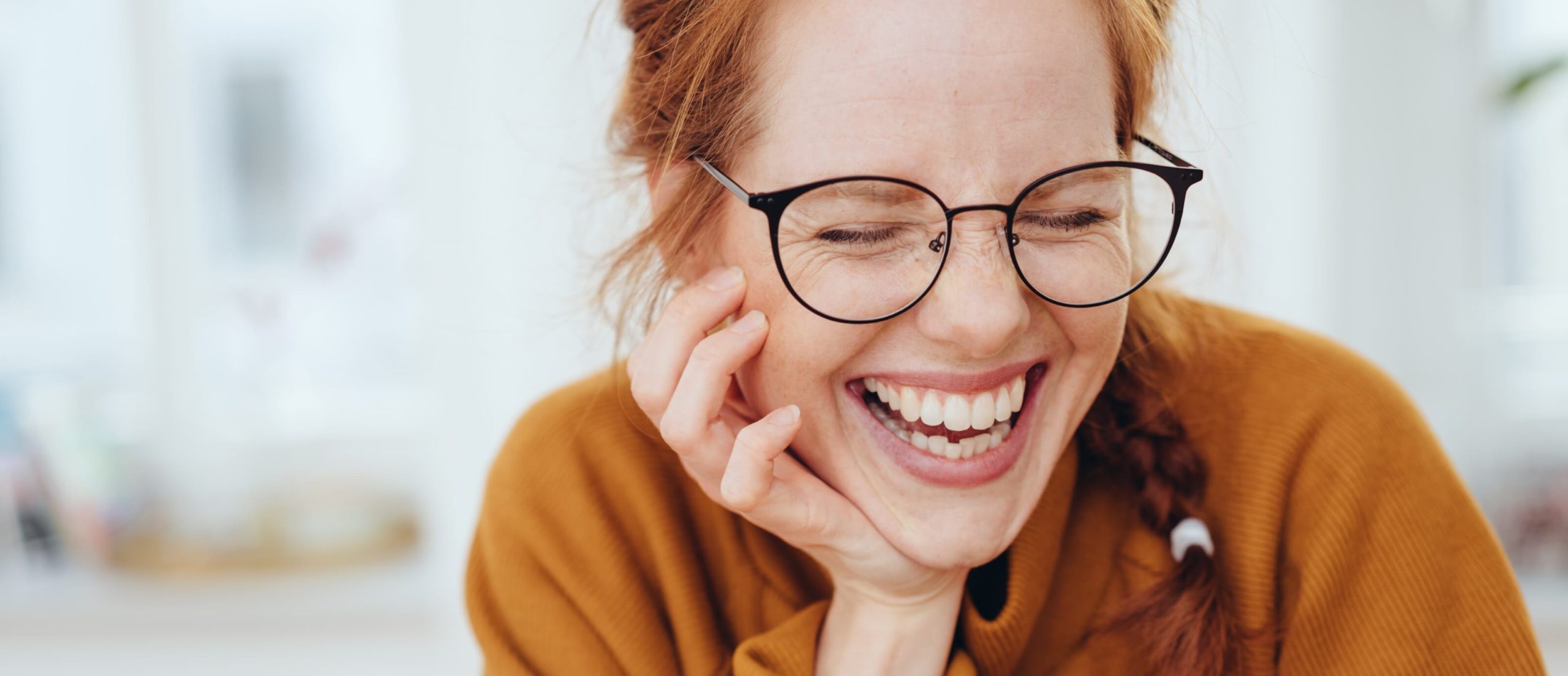 Lachende Frau mit schwarzer Brille