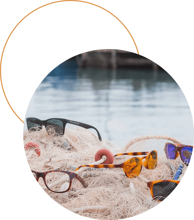 Mehrere Sonnenbrillen liegen auf einem Fischernetz